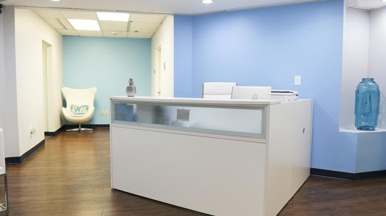 Reception area at 5457 Twin Knolls Road, Suite 300, Columbia (Maryland) with blue walls and a white desk.