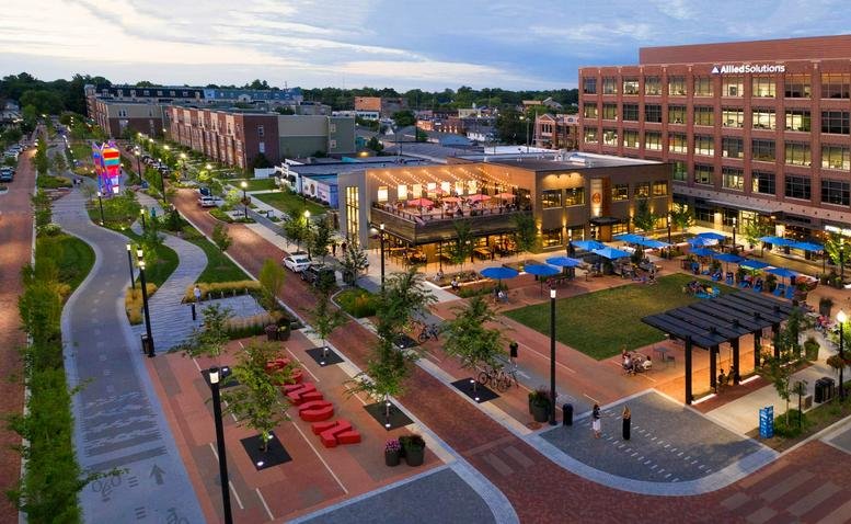 Elevated evening view of the 571 Monon Boulevard, Suite 200 plaza with lit pathways and modern buildings.