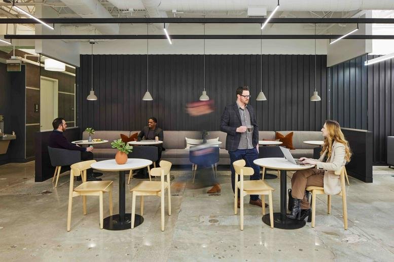 Spacious communal lounge at 5775 Glenridge Drive, Lakeside, Building C with café seating and wood accents.