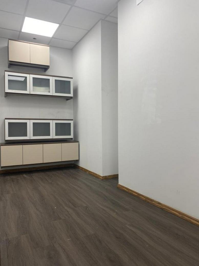 Interior office space at 580 5th Avenue, Suite 210 with modern cabinetry and dark wood floors.