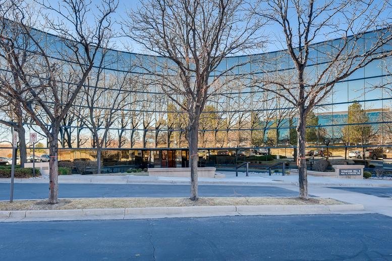Curved glass facade exterior of the Syracuse Hill II building at 6041 South Syracuse Way.