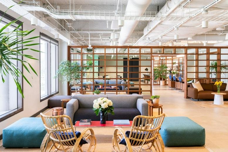 Spacious sun-drenched lounge with mid-century furniture and plants at 611 North Brand.
