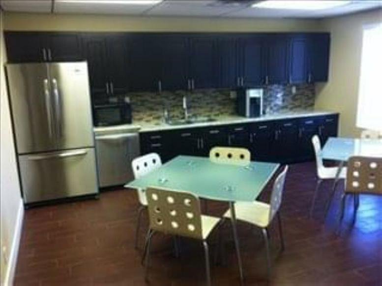 Communal kitchen area at 6166 South Sandhill Road featuring dark cabinetry and a stainless steel refrigerator.