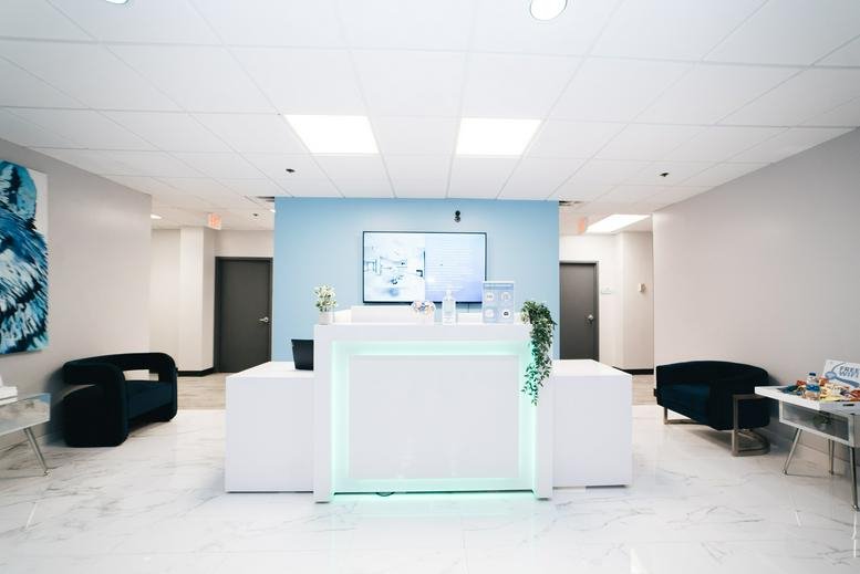 Modern lobby and reception area at 6200 Baltimore Avenue, Suite 300, with a glowing desk and blue accent wall.
