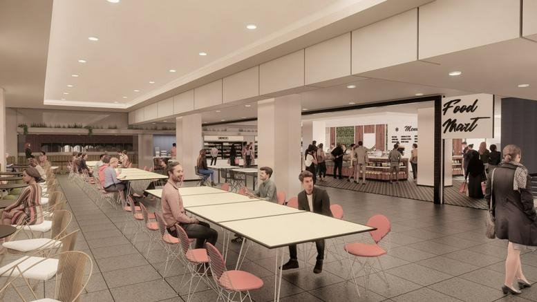 Large cafeteria with long communal tables and a food market sign.