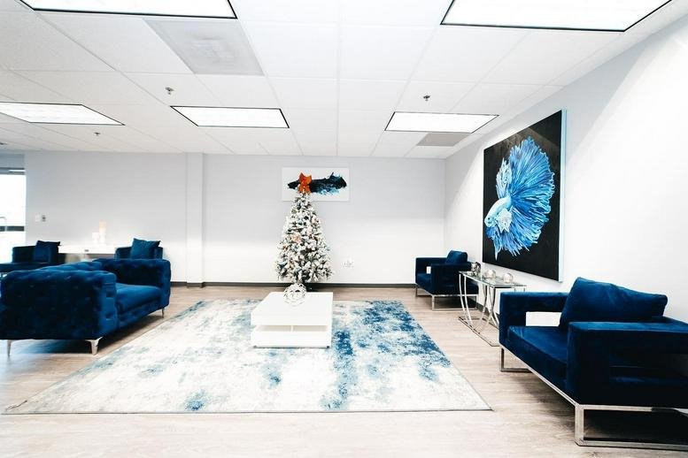 Spacious lounge at 6340 Security Boulevard, Suite 100 featuring blue sofas and a decorative holiday tree.