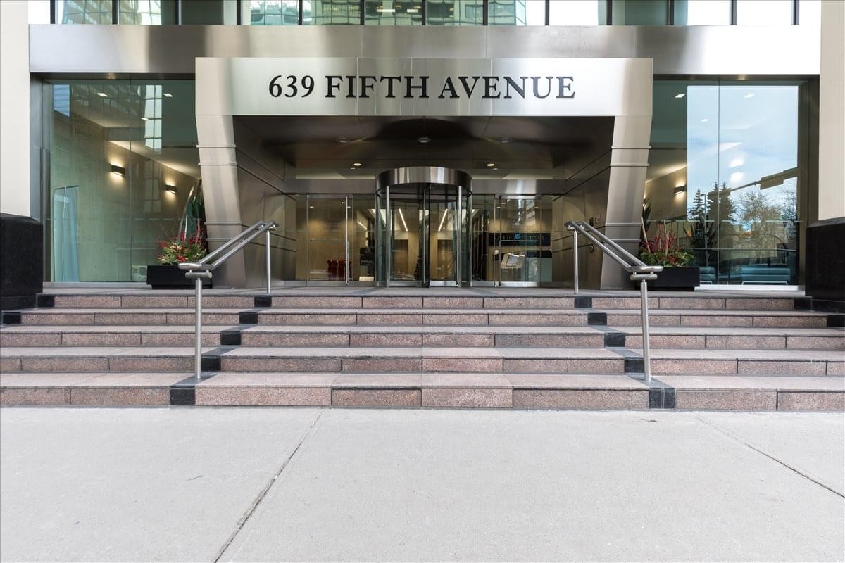 Exterior entrance of 639 Fifth Avenue featuring a modern glass revolving door and steps.