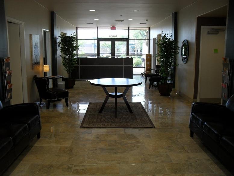 Spacious reception lobby with a central round table and polished floors.