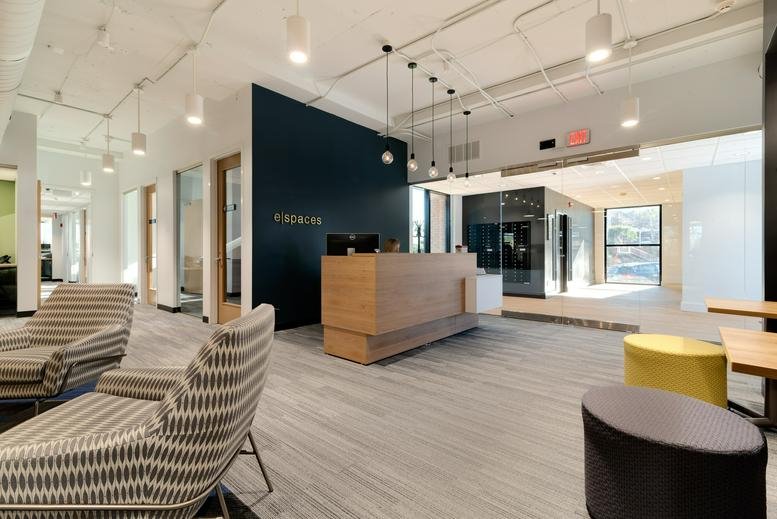 Bright reception lobby at 651 E. 4th Street, Chattanooga, Tennessee featuring a wood desk and stylish armchairs.