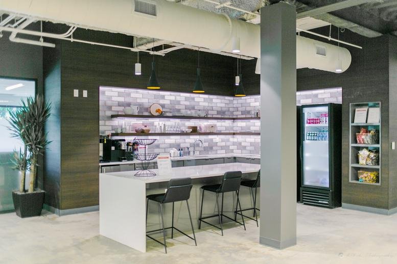 Spacious communal breakroom at 6584 Poplar Avenue, 2nd Floor, featuring a modern kitchen island and high-top seating.