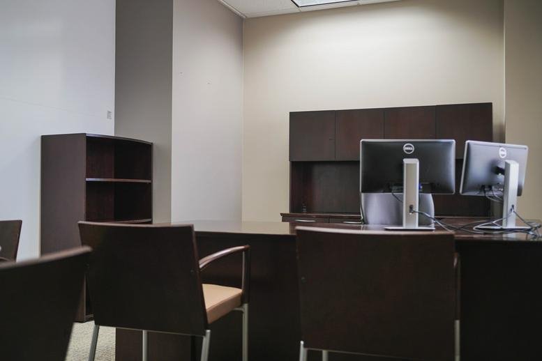 Executive office at 6601 Park of Commerce Boulevard with dark wood furniture and multiple monitors.