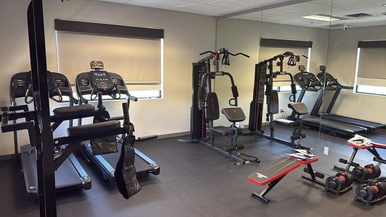 On-site fitness center with treadmills, weight benches, and strength equipment.