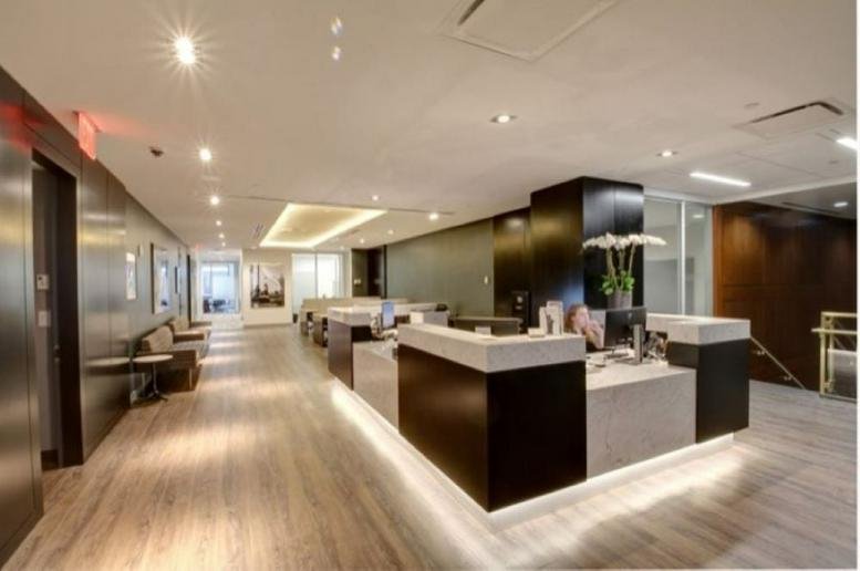 Spacious reception area at 667 Madison Avenue, 4th & 5th Floor, New York City with sleek black and white desks.