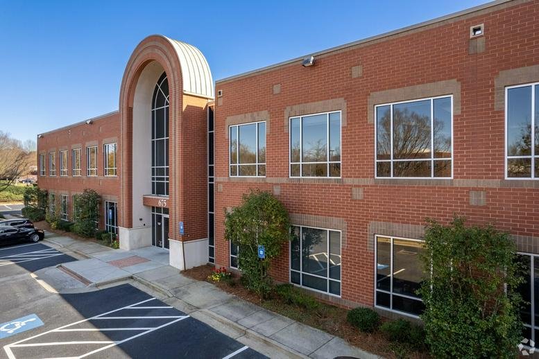 Exterior view of the brick facade and arched entrance at 675 Mansell Road, Mansell West Office Park.