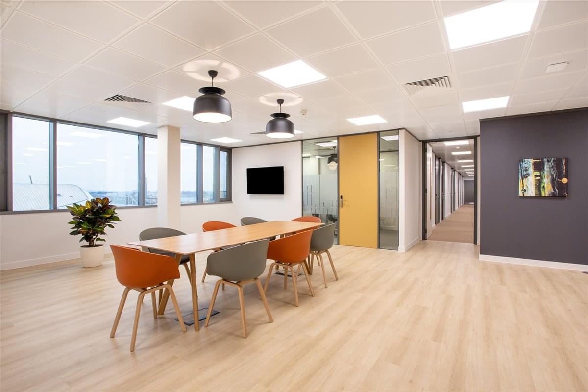 Spacious communal area at 6920 Brisbane Court, 2nd Floor, featuring wood floors and orange chairs.