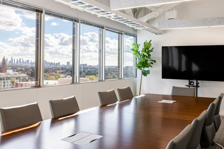 Spacious boardroom at 6922 Hollywood Boulevard with a large wood table and panoramic city views.