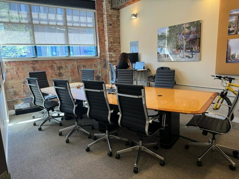 Meeting room at 7 N Willow St, No. 6, Montclair, New Jersey with a large wood table and brick accent wall.