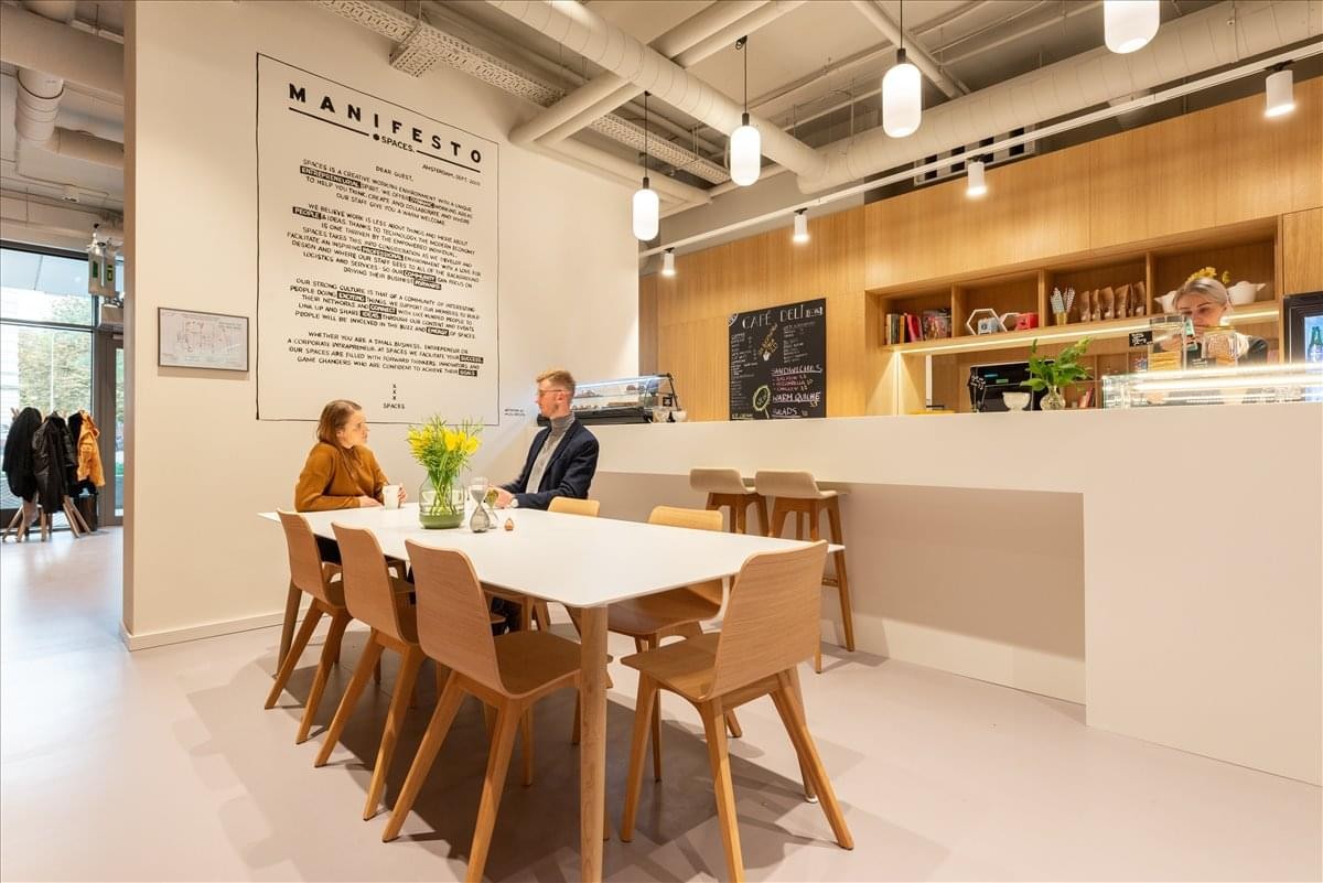 Spacious communal cafe and lounge area at 700 Nexton Square Drive with warm lighting and wooden furniture.