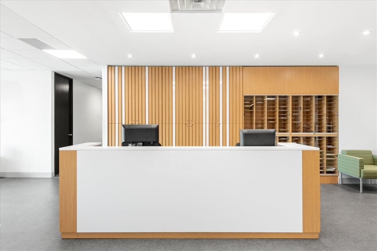 Bright, modern reception area at 7030 Woodbine Avenue, Suite 500 featuring a white and wood desk.