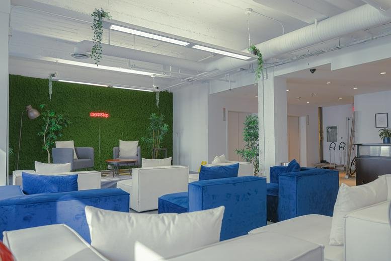 Modern lounge at 717 West Pender Street with blue velvet seating and a green feature wall.