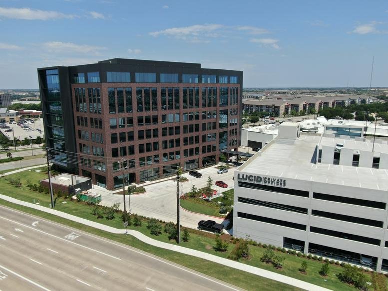 Exterior view of the brick and glass building at 7300 State Highway 121, Suite 300.