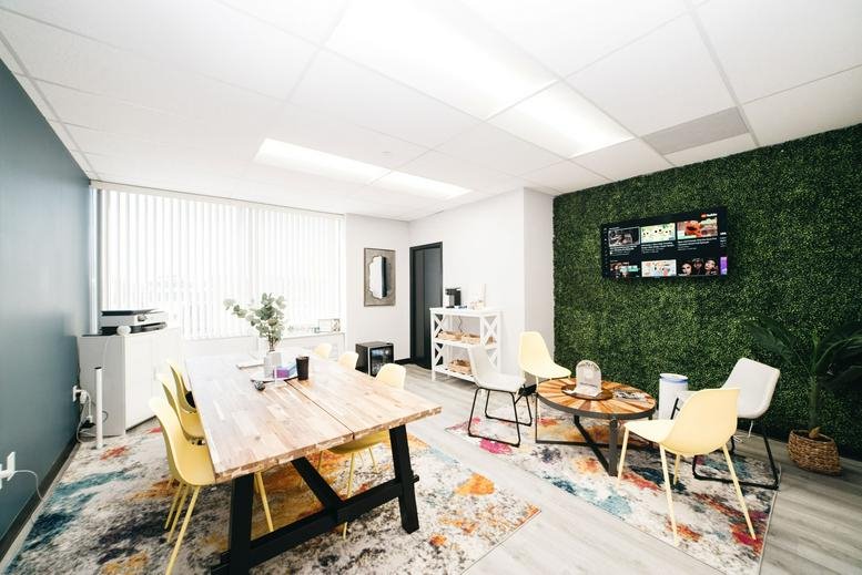 Vibrant coworking lounge at 7310 Ritchie Highway, Suite 200 with a green moss wall and colorful rug.