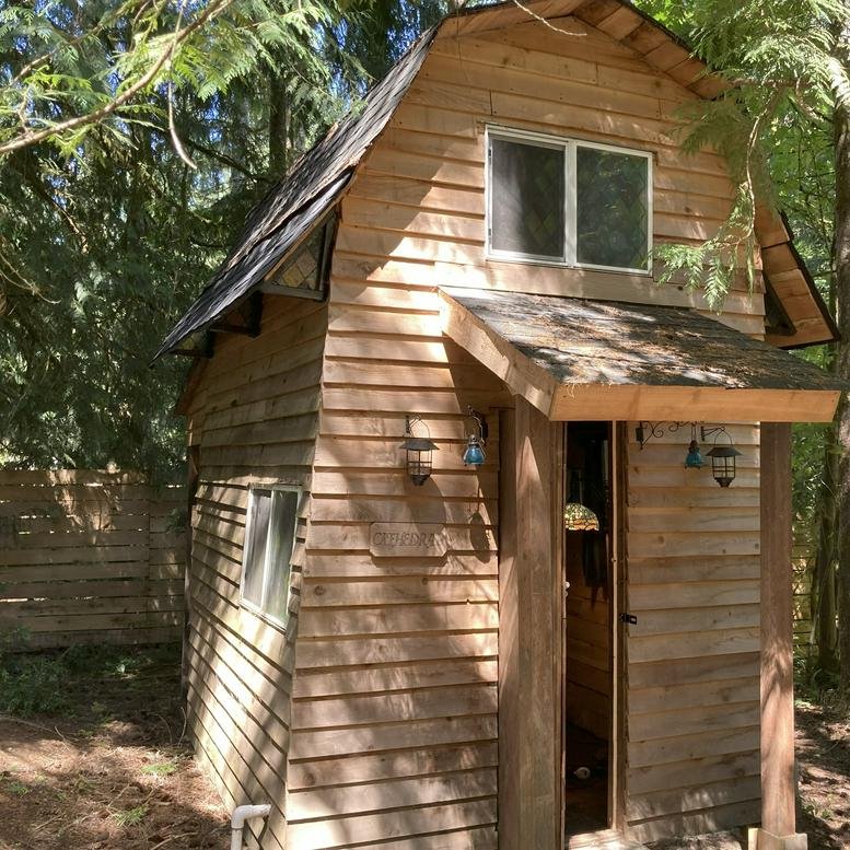 Exterior view of the rustic wood-sided office cabin at 7419 Ebbert Drive Southeast.