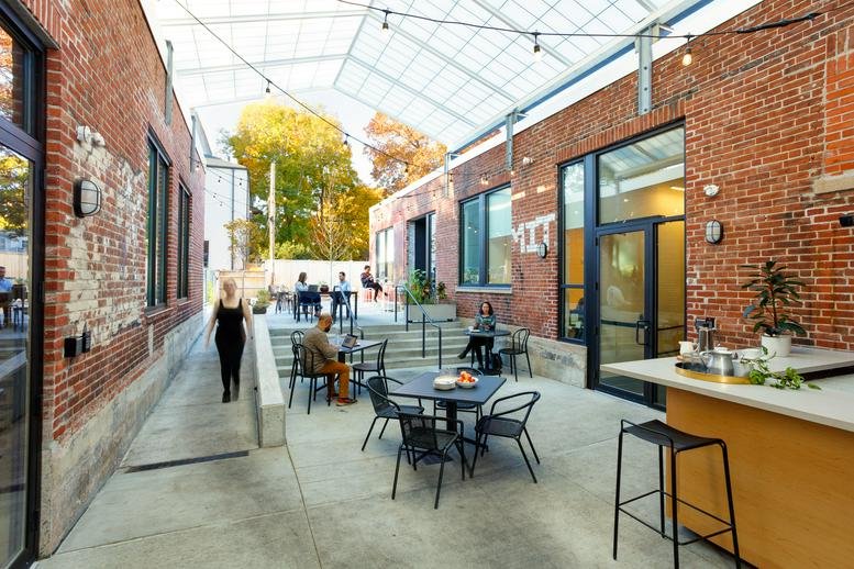 Spacious covered outdoor courtyard at 769 Centre Street Jamaica Plain with brick walls and seating.