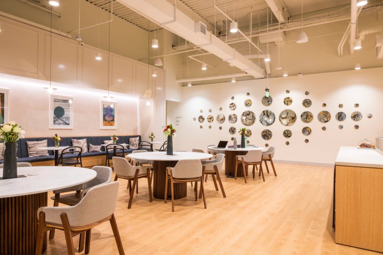 Spacious communal lounge at Legacy Place featuring round marble tables, velvet seating, and wall art.