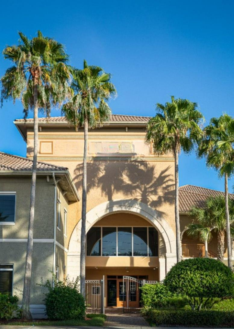 Exterior entrance of 770 South East Indian Street featuring a large archway and tropical palm trees.