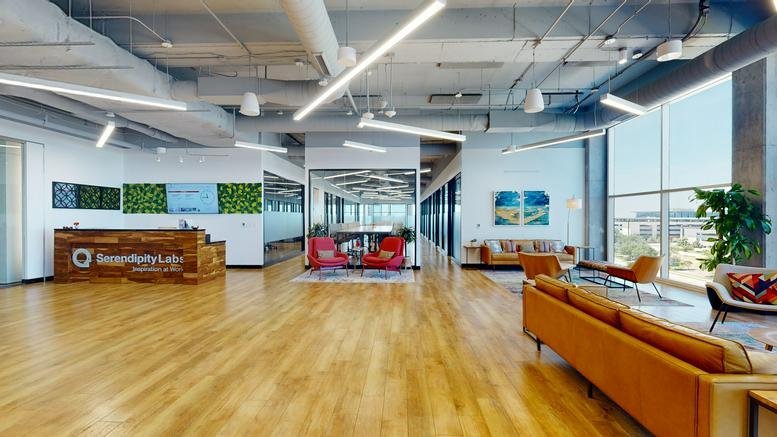 Wide view of the office entrance lobby featuring polished wood floors and multiple seating zones.