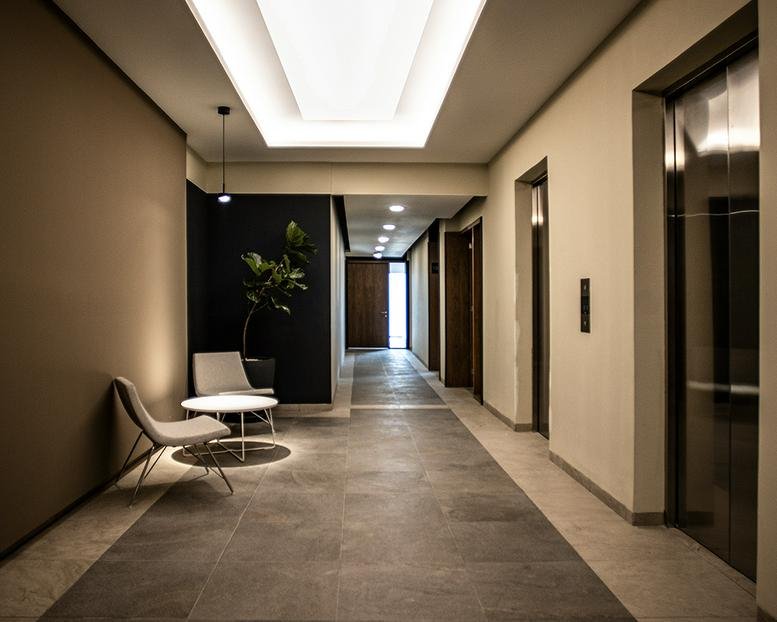 Sleek lobby area at 799, Prolongación Paseo de la Reforma with modern chairs and a dark accent wall.