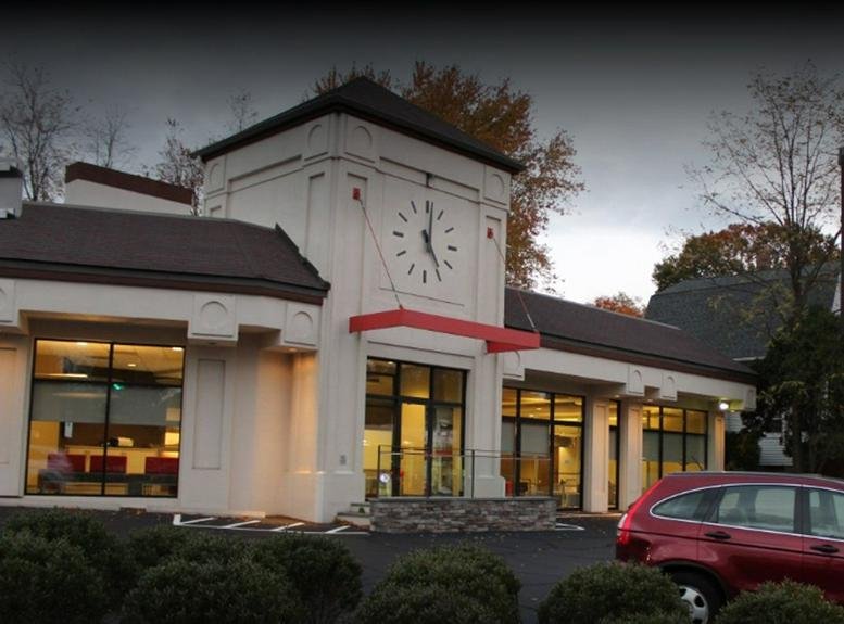 Exterior view of the white building with a clock tower at 80 Theodore Fremd Avenue.