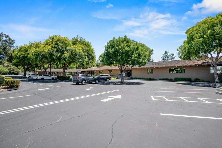 Parking area and exterior view of the low-profile professional building at 80 Willow Road, Menlo Park.