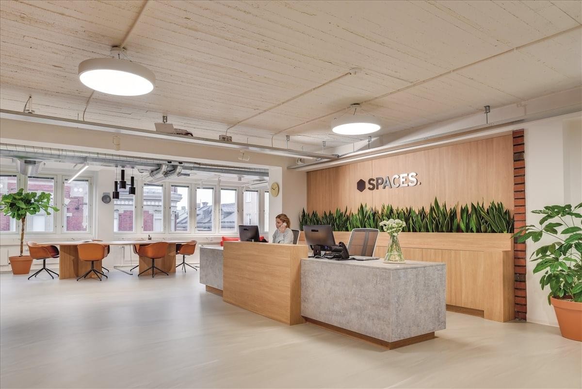Reception area at 801 Brickell Avenue with a light wood desk, greenery, and modern lighting.