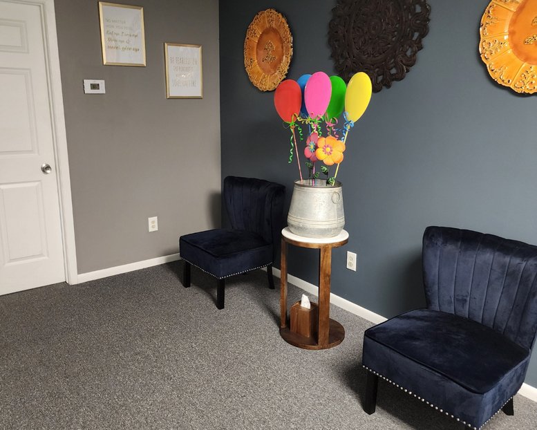 Reception area at 8231, Hohman Avenue, Suite 200 2nd floor featuring velvet chairs and colorful balloon decor.