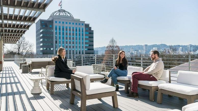 Rooftop terrace at 830 Northeast Holladay Street with lounge seating and views of the surrounding city skyline.