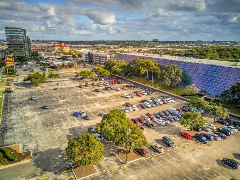 Aerial view of the building at 84 Northeast Loop 410 showing the parking lot and surrounding area.