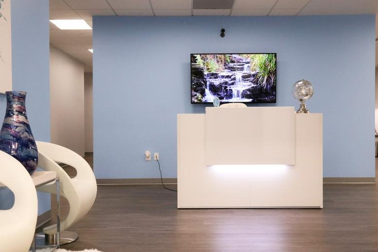 Reception area at 8507 Oxon Hill Road, Suite 200, Fort Washington (Maryland) featuring a white desk and blue walls.