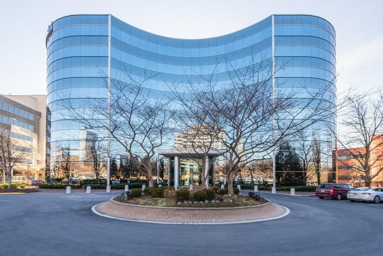 Exterior view of the curved glass facade at 8609 Westwood Center Drive.