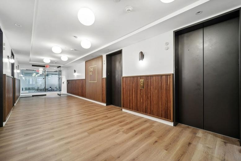 Spacious elevator lobby at the Bowen Building with warm wood paneling and bright overhead lighting.