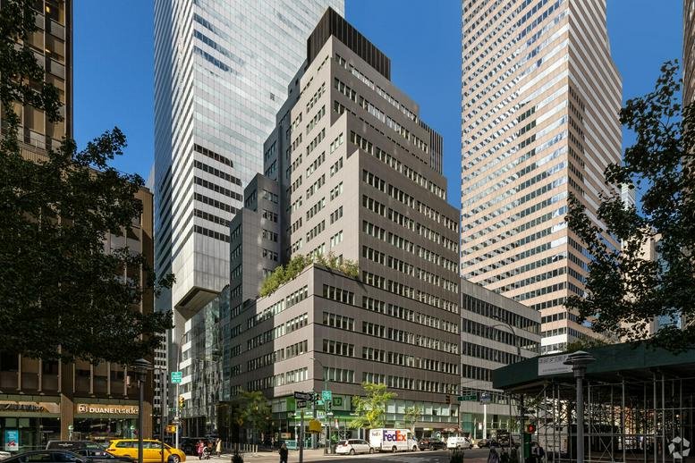 Wide exterior shot showing the building at 880 3rd Avenue within the city skyline.