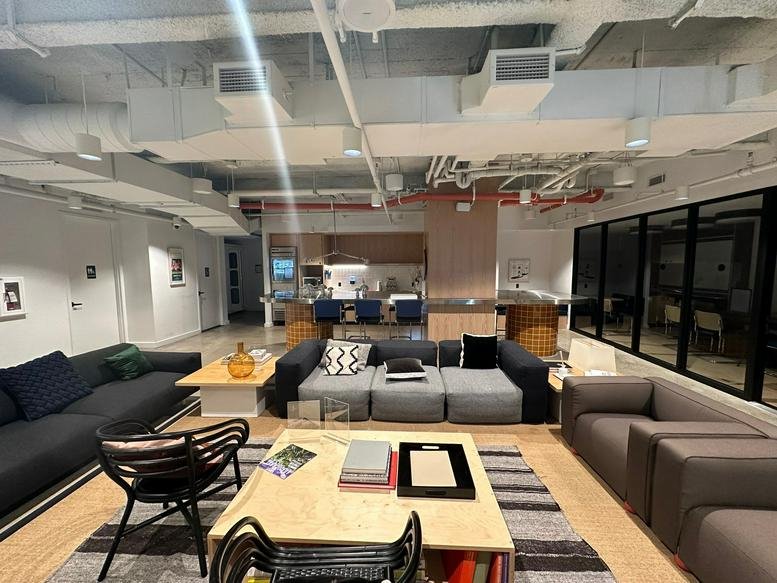Comfortable lounge area with various seating options and industrial-style ceiling.