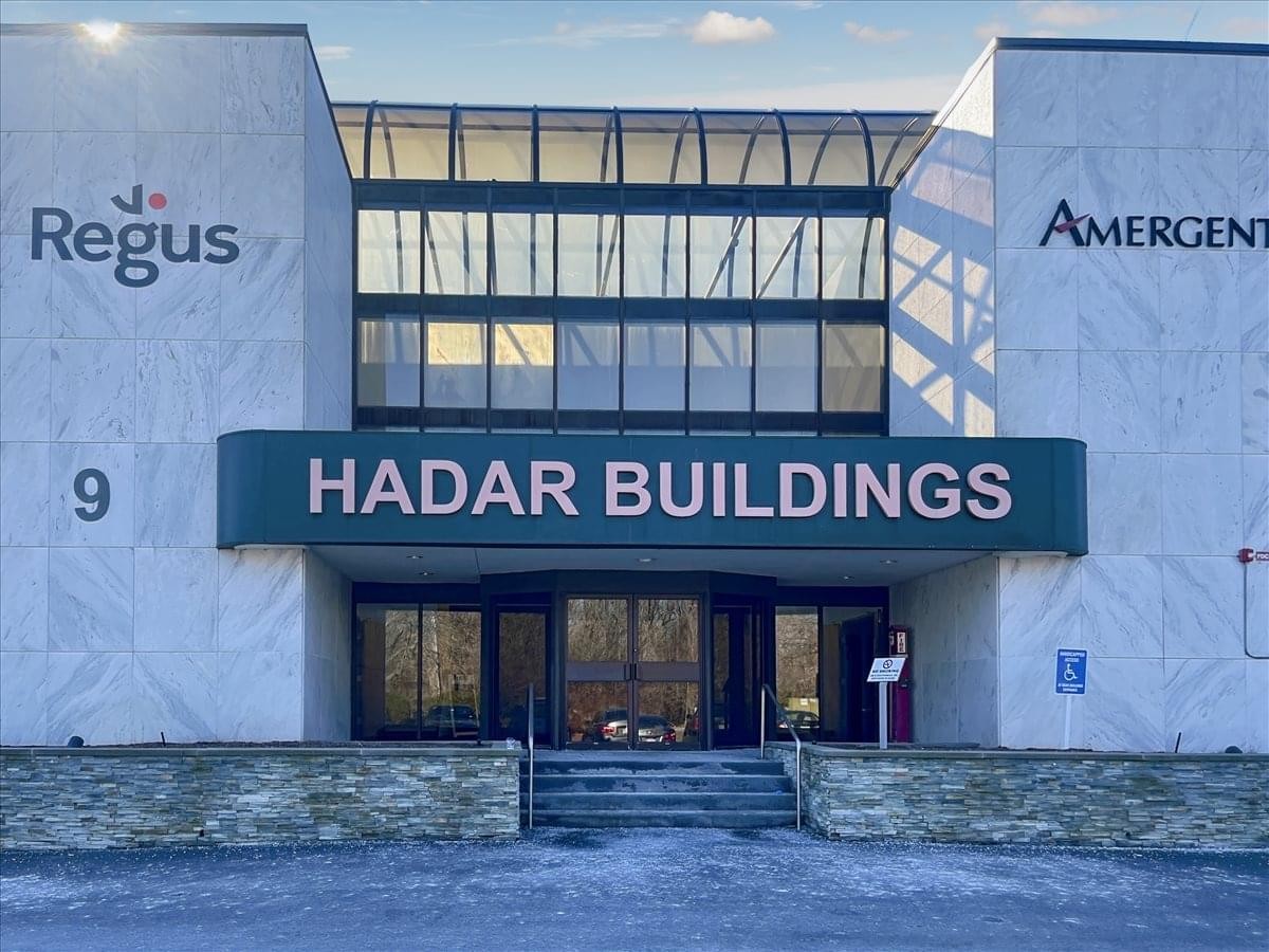 Exterior view of the entrance at 9 Hadar Buildings featuring signage and large windows.