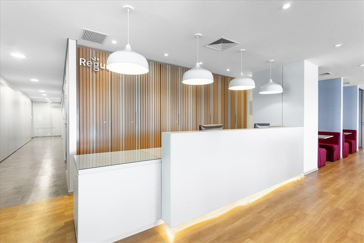 Modern reception area at 90 Dolorez Alcaraz Caldas Ave with a sleek white desk and warm wood paneling.