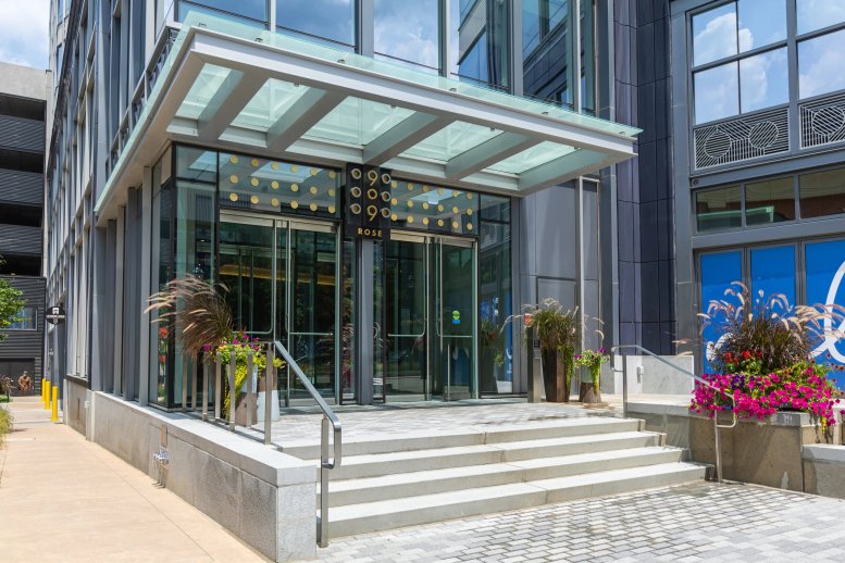 Exterior entrance of 909 Rose Avenue at Pike & Rose under a glass canopy.