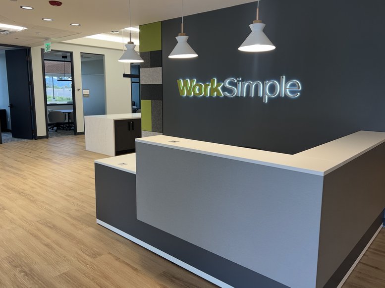 Professional reception desk with WorkSimple branding and modern pendant lighting at 9191 Sheridan Boulevard.