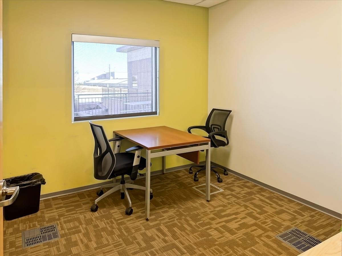 Private two-person office suite with a yellow feature wall and window view at 943 West Overland Road.