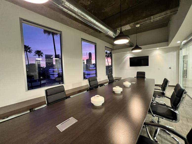 A professional boardroom at 9777 Wilshire Boulevard, Suite 400, TD Ameritrade, with a long wood table and sunset views.