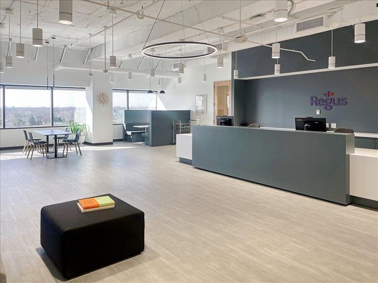 Spacious lobby and reception area featuring a sleek grey desk and modern circular lighting.